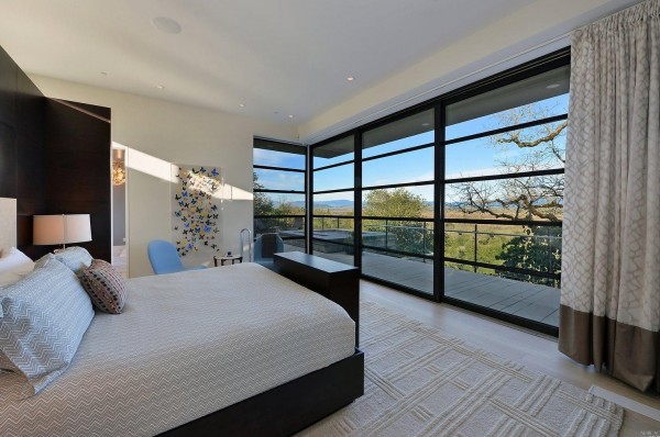 Master Bedroom highlights include wood flooring, fireplace, dual closets with built- in safe, retractable built-in television, and adjacent sitting room.  Glass walls open to the terrace and magnificent vantage points. 